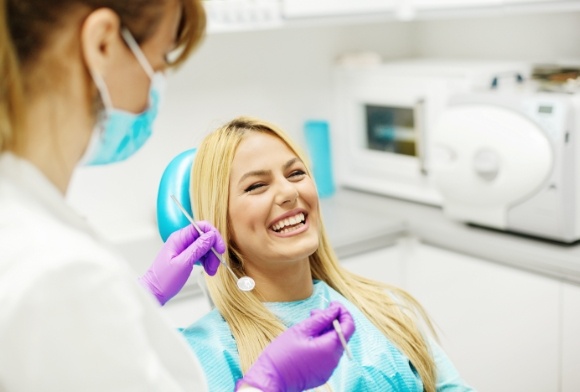 Woman laughing during dental checkup and teeth cleaning visit