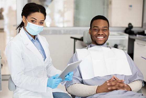 Male patient smiling while visiting his in-network dentist