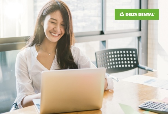 Woman reviewing dental insurance forms with Delta logo in background