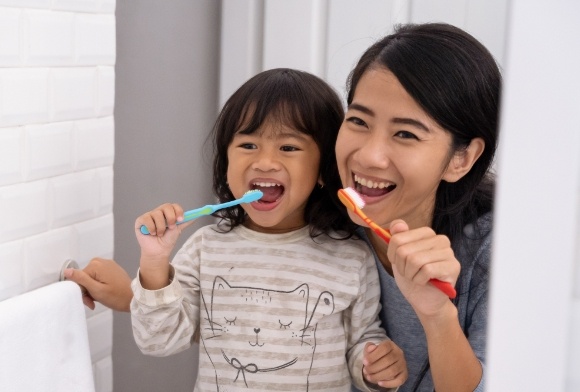 Mother and child brushing teeth to prevent dental emergencies