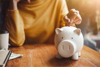 Woman putting money into a piggy bank