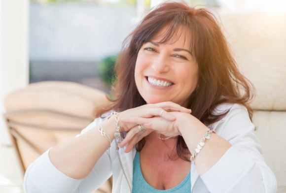 Woman smiling after dental implant denture