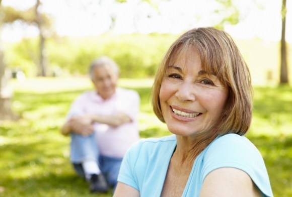 Woman with dental implant supported replacement teeth smiling