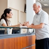 Man checking in at dental office reception desk