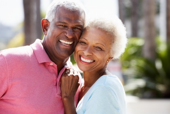 Older couple enjoying well cared for dental implant supported replacement teeth