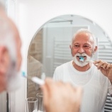 Man with dental implant tooth replacement making oral hygiene a priority