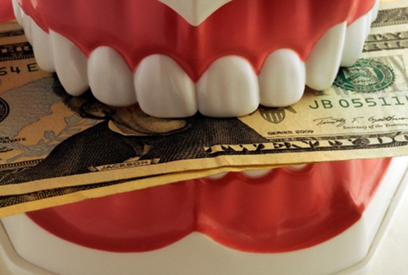 A model jaw biting dollar bills 