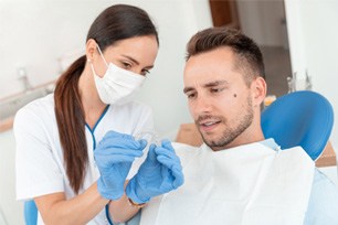 A dentist showing her patient an Invisalign aligner