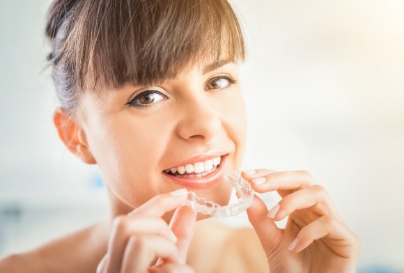 Woman placing an Invisalign tray