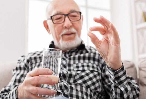 Man taking antibiotic therapy pill for periodontal disease treatment