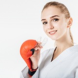 Young girl smiling while holding mouthguard