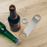 Bottle cap opener next to brown and green bottles