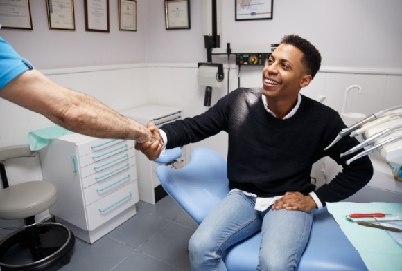 Man shaking hands with dentist after preventive dentistry checkup and teeth cleaning visit