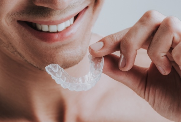 Patient placing mouthguard to treat bruxism