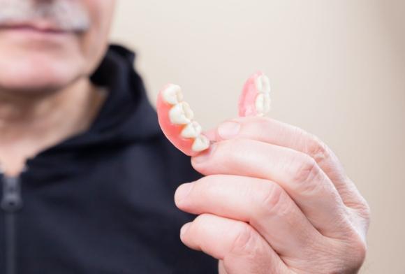 Patient holding a denture