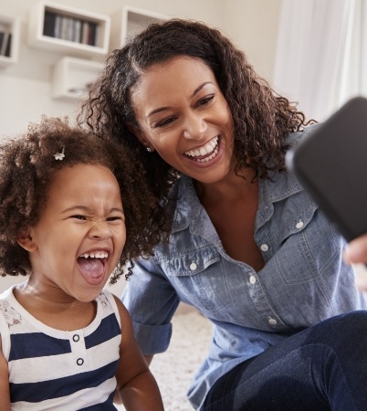 Mother and child smiling together after children's dentistry visit