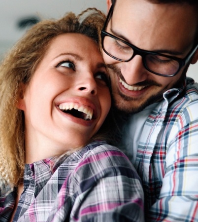 Man and woman with healthy smiles after gum disease treatment