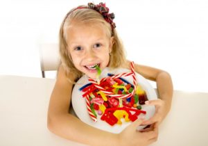 child with a bowl of candy