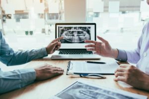 Dentist and patient review dental x-rays at oral exam