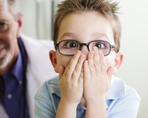 Shocked little boy covers his mouth hearing about tooth infection