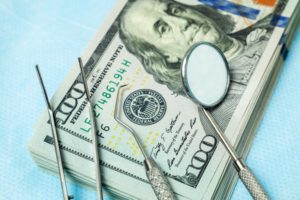 Cost of sedation dentistry signified by money and dental tools
