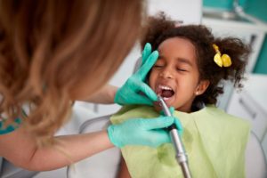 a child getting her tooth treated at the dentist