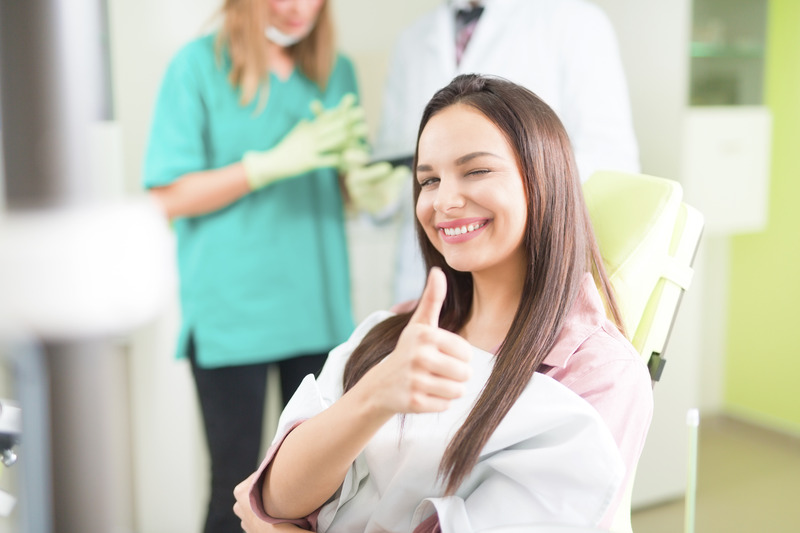 Patient smiling at dentist after emergency dental care