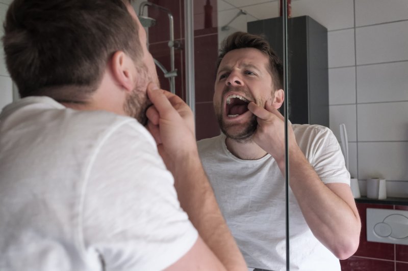 Patient with diabetes checking gum disease in mirror