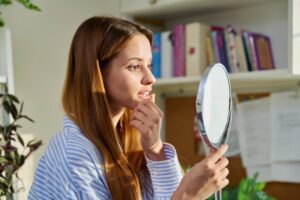 Woman looking at her gums in the mirror